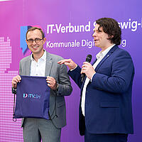 Matthi Bolte-Richter überreicht Dirk Schrödter ein kleines Souvenir an das ITV.SH Forum