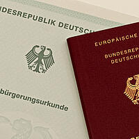 Nahaufnahme einer Einbürgerungsurkunde und eines Reisepasses der BRD
