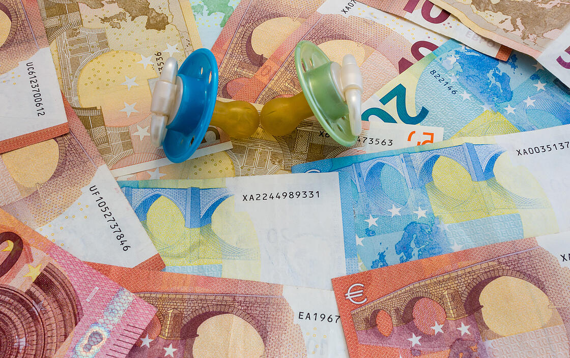 Nahaufnahme zweier Schnuller auf Euro-Geldscheinen