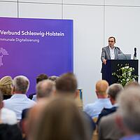 Digitalisierungsminister und CdS Dirk Schrödter bei seinem Grußwort im großen Vortragssaal.