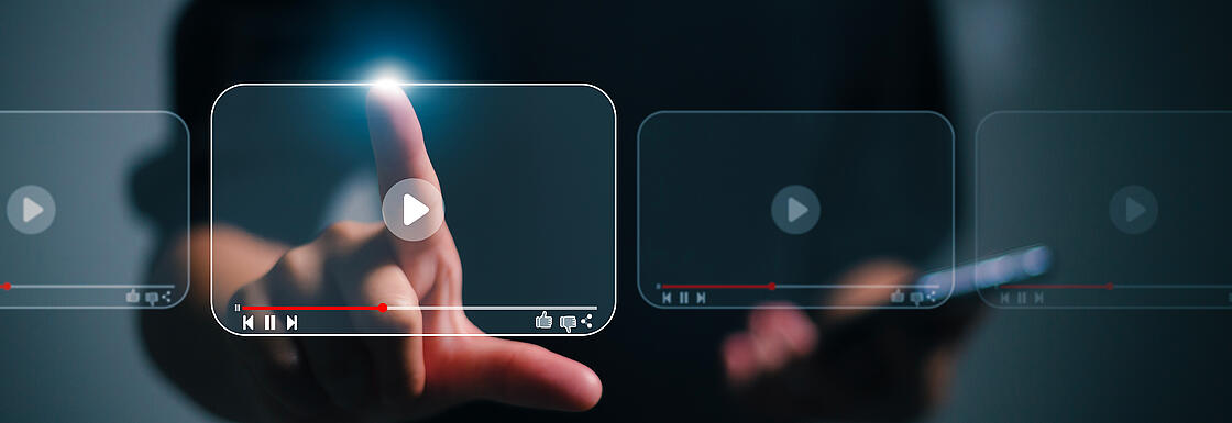 Eine Person die auf ein Bildschirmsymbol tippt, auf dem ein Video abspielen Symbol gezeigt wird.