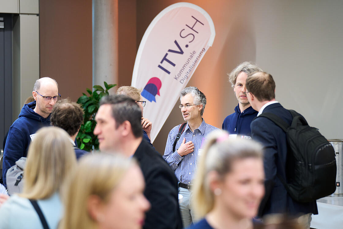 Teilnehmende des ITV.SH Forums im Foyer beim Austausch.