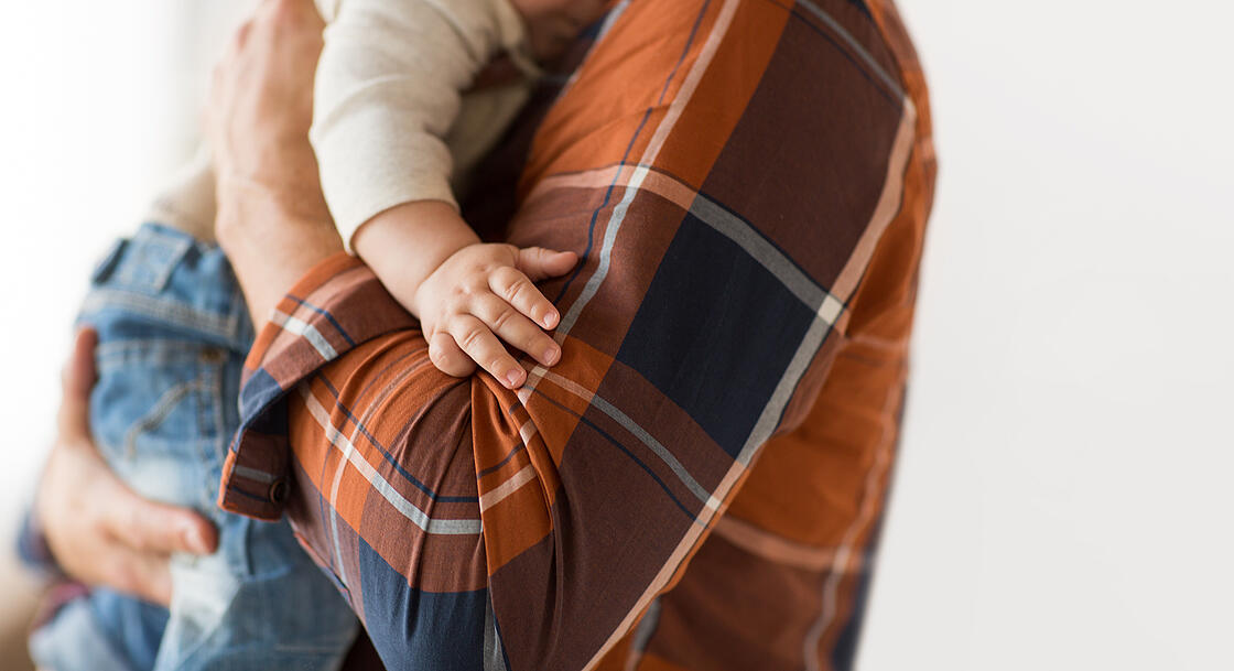 Nahaufnahme eines Babys auf dem Arm seines Vaters