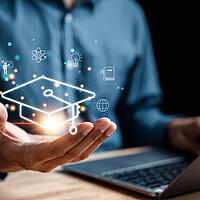 Person sitzend vor Rechner und leuchtende digitale Symbole für E-Learning und Webinare