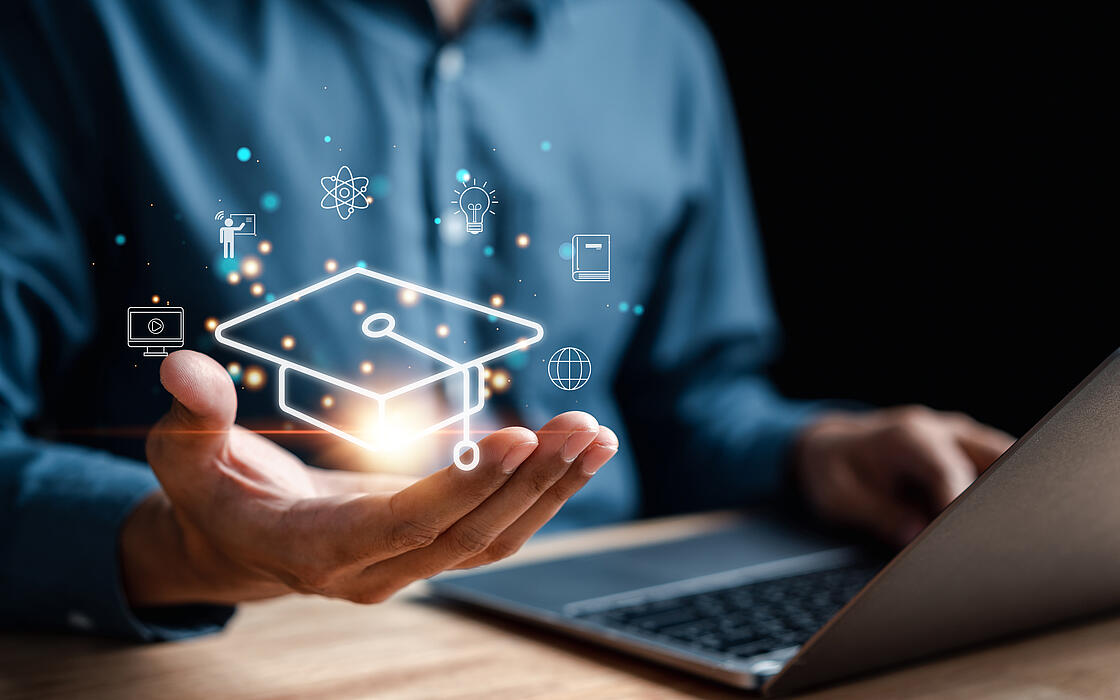 Person sitzend vor Rechner und leuchtende digitale Symbole für E-Learning und Webinare