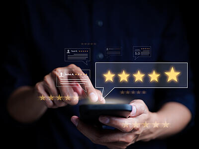 Ein Nutzer gibt über sein Handy eine Bewertung (fünf Sterne) ab.
