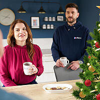 Mitarbeiter:innen des ITV.SH beim Kaffee mit Weihnachtsbaum